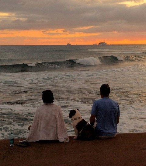 A couple watching the sunset together over the ocean